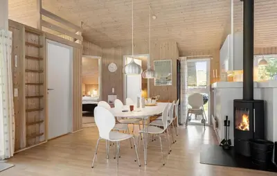 a dining room with a table and chairs and a fireplace at 4 Bedroom Awesome Home In Saltum in Saltum