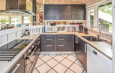 a kitchen with wooden cabinets and white appliances at Stunning Home In Saltum With Sauna in Saltum