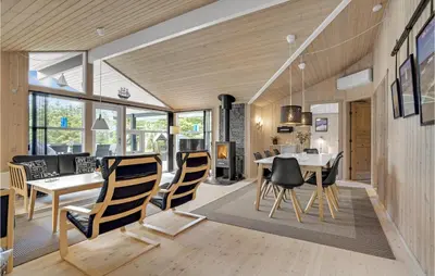 a dining room and living room with a table and chairs at Holiday Home Jægerens Vej in Blokhus