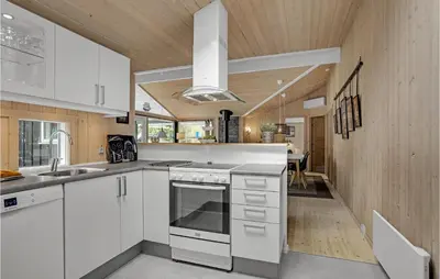 a kitchen with white cabinets and a sink at Holiday Home Jægerens Vej in Blokhus