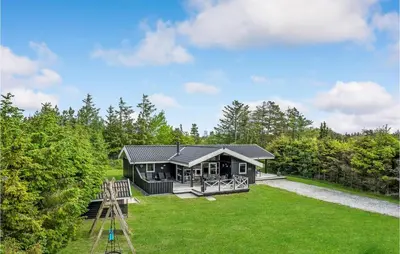 a home in the woods with a large yard at Holiday Home Jægerens Vej in Blokhus