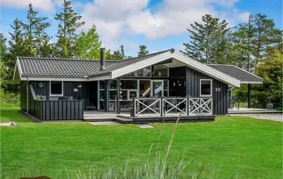 a black house with a large yard at Holiday Home Jægerens Vej in Blokhus