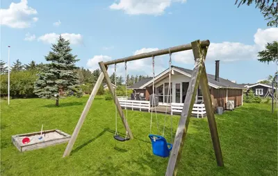 a swing set in the yard of a house at Holiday Home Kristavej Løkken Xii in Løkken