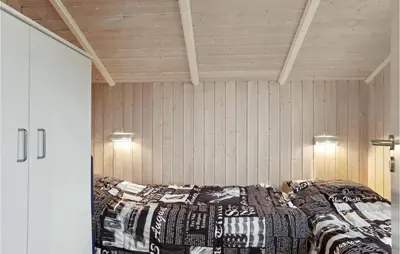 two beds in a room with wooden walls at Holiday Home Kristavej Løkken Xii in Løkken