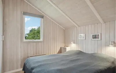 a bedroom with a bed and a window at Holiday Home Kristavej Løkken Xii in Løkken