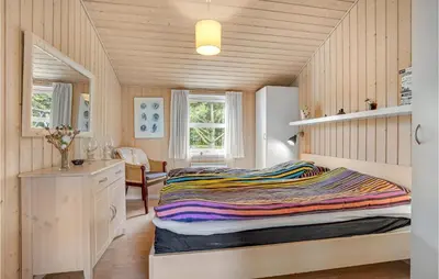 a small bedroom with a bed and a desk at Holiday Home Stellavej Løkken Denm in Løkken