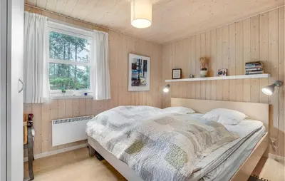 a bedroom with a bed and a window at Holiday Home Stellavej Løkken Denm in Løkken
