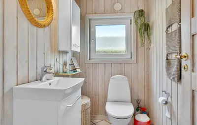 a bathroom with a toilet and a sink and a window at Lovely Home In Saltum With Kitchen in Saltum