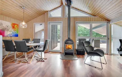 a dining room with a table and a fireplace at Lovely Home In Saltum With Kitchen in Saltum