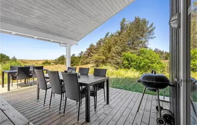 a patio with a table and chairs and a grill at Awesome Home In Blokhus With Wifi in Blokhus