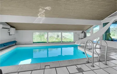 a swimming pool with a slide in a house at Awesome Home In Blokhus With Wifi in Blokhus