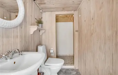 a bathroom with a white sink and a toilet at Holiday Home Lyngvej Blokhus Iv in Blokhus
