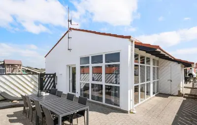 a white house with a table and chairs at Stunning Home In Blokhus With Sauna in Blokhus