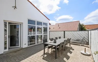 a patio with a wooden table and chairs at Stunning Home In Blokhus With Sauna in Blokhus