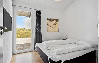a white bedroom with a bed and a window at Stunning Home In Blokhus With Sauna in Blokhus