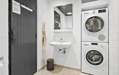 a bathroom with a sink and a washing machine at Stunning Home In Blokhus With Sauna in Blokhus