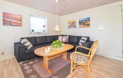 a living room with a couch and a table at Holiday Home Kristinesvej Blokhus X in Blokhus