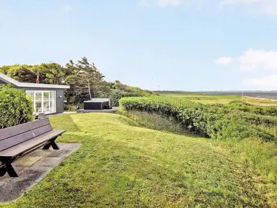 a wooden bench sitting in the grass next to a house at 6 person holiday home in Vinderup-By Traum in Vinderup