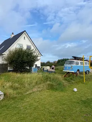 a van parked in a yard next to a house at Viking Surf House in Klitmøller