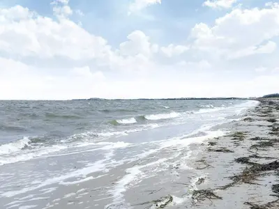 a beach with the ocean and a cloudy sky at 8 person holiday home in Løgstør-By Traum in Løgsted