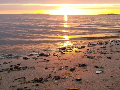 a beach with the sun setting over the water at 8 person holiday home in Løgstør-By Traum in Løgsted