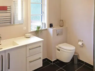 a bathroom with a toilet and a sink and a window at 8 person holiday home in Løgstør-By Traum in Løgsted