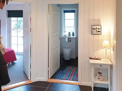 a bathroom with a door leading to a toilet at 8 person holiday home in Løgstør-By Traum in Løgsted