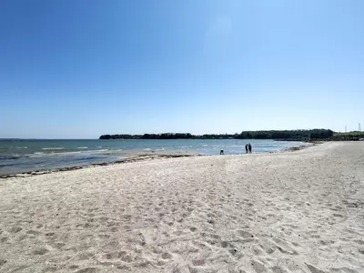 a group of people walking on a sandy beach at 4 person holiday home in Brovst-By Traum in Brovst