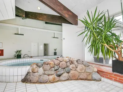 a pool in a room with a large rock formation at 4 person holiday home in Brovst-By Traum in Brovst