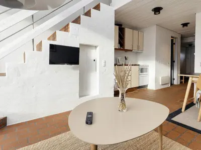 a living room with a table and a tv on a wall at 4 person holiday home in Brovst-By Traum in Brovst