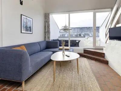 a living room with a blue couch and a table at 4 person holiday home in Brovst-By Traum in Brovst