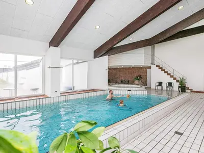 two people swimming in a large indoor swimming pool at 6 person holiday home in Brovst-By Traum in Brovst