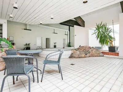 a patio with chairs and a table and a rock formation at 6 person holiday home in Brovst-By Traum in Brovst