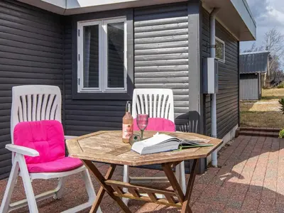 two chairs and a table with a glass of wine at 6 person holiday home in Løgstør-By Traum in Løgsted
