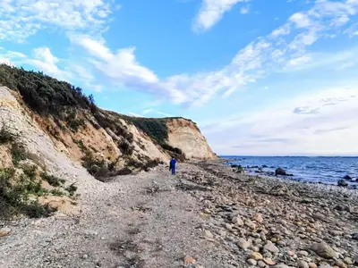 a person walking on a rocky beach near the ocean at 6 person holiday home in Løgstør-By Traum in Løgsted