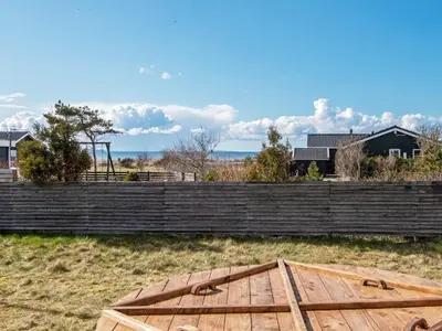 a wooden table in a field next to a fence at 6 person holiday home in Løgstør-By Traum in Løgsted