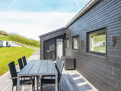 a wooden deck with a table and chairs on a house at 6 person holiday home in Lemvig-By Traum in Lemvig