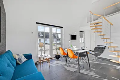 a living room with a blue couch and a table and chairs at Lildgaard in Frøstrup