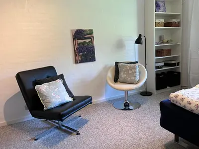 a room with a bedroom with a chair and a bed at Kørestolsvenligt dbl. vær. in Nykøbing Mors