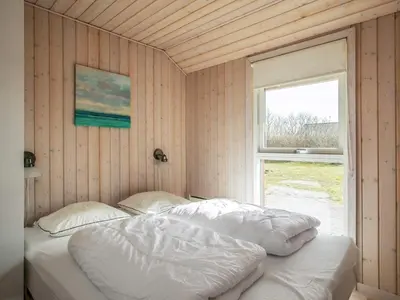 two beds in a room with a window at 8 person holiday home in Brovst-By Traum in Brovst