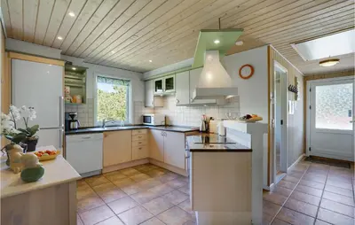 a kitchen with white appliances and a wooden ceiling at Awesome Home In Løgstør With Sauna in Løgstør