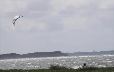 a person is flying a kite on the beach at Awesome Home In Løgstør With Sauna in Løgstør