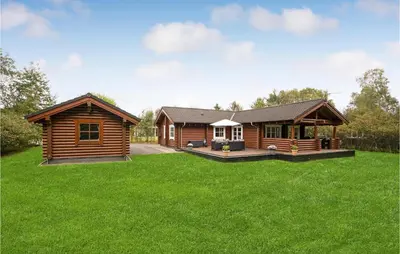 a log cabin in a yard with green grass at Holiday Home Ramshule Farsø Xii in Farsø