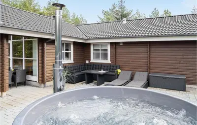 a backyard with a hot tub in front of a house at Holiday Home Benediktesvej Løgstør X in Løgstør