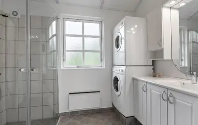a white bathroom with a sink and a washer and dryer at Holiday Home Kjeldhøj Farsø Xi in Farsø