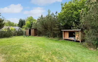 a yard with two wooden structures in the grass at Holiday Home Kjeldhøj Farsø Xi in Farsø