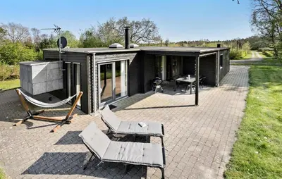 a small black house with chairs and a table at Amazing Home In Løgstør With Kitchen in Løgstør