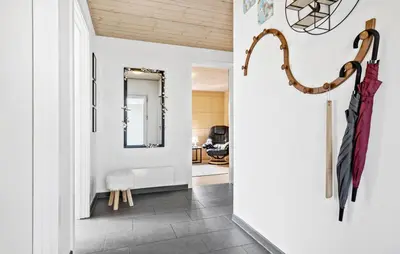 a hallway with umbrellas hanging on a wall at Amazing Home In Løgstør With Kitchen in Løgstør