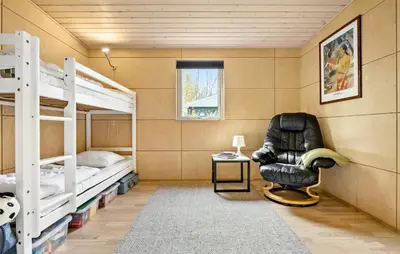 a room with two bunk beds and a chair at Amazing Home In Løgstør With Kitchen in Løgstør