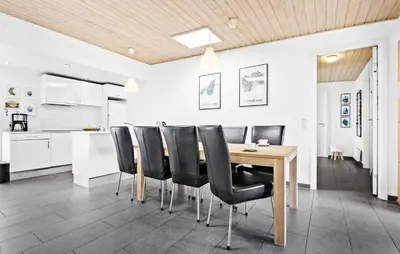 a kitchen and dining room with a wooden table and black chairs at Amazing Home In Løgstør With Kitchen in Løgstør
